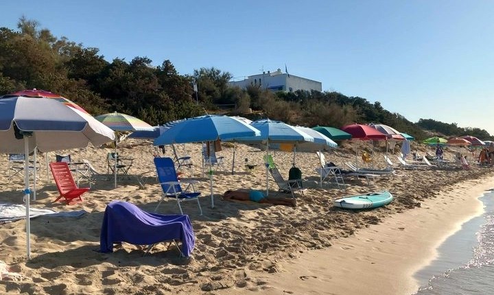 Ombrelloni segnafila nella spiaggia fantasma